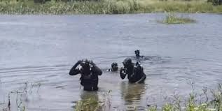 Rescue team at a dam shoreline — Sub Aqua Unit responding to a recovery operation