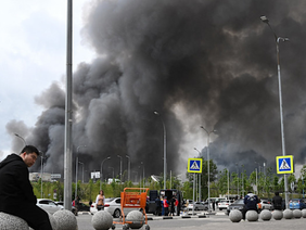 Mid-shot of a damaged high-rise residential apartment block in the Moscow suburb of Zhukovsky being evaluated by emergency responders.
