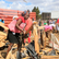 woman picking up pieces of her destroyed market stall