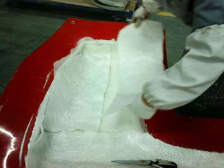 Kompozit üretiminde cam elyaf ve polyester reçine ile laminasyon yapan üretim çalışanı