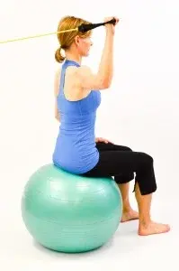 Woman on gym ball doing rotator cuff exercise