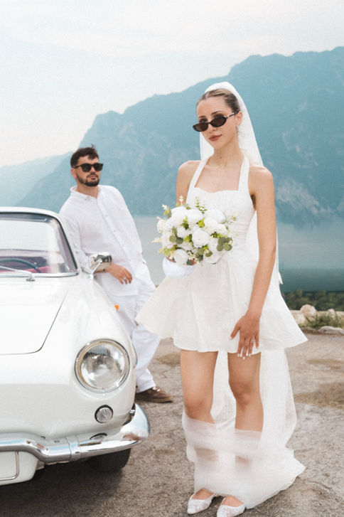 Editorial destination wedding photographer – bride portrait with vintage car in the Dolomites, Italy