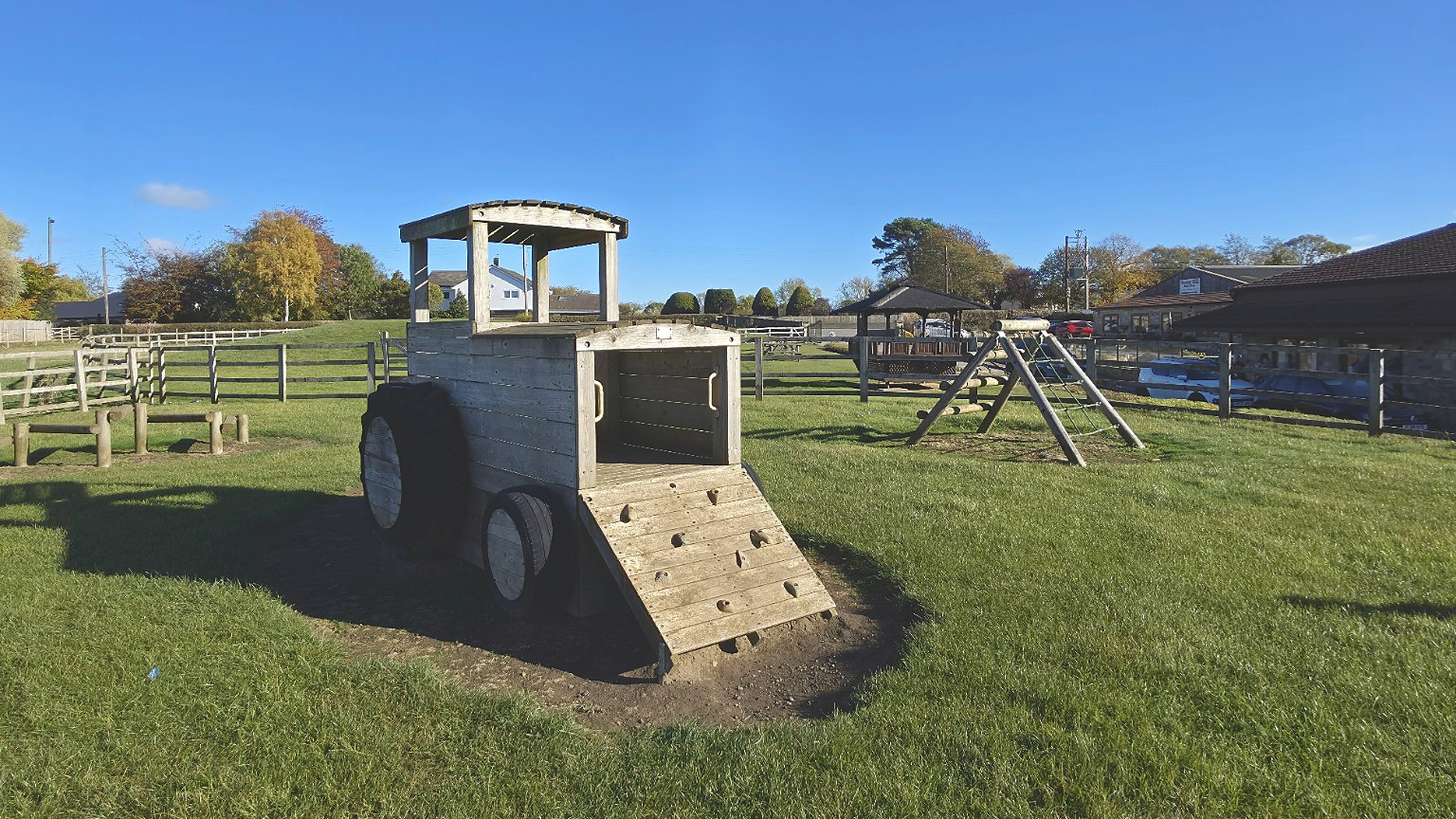 Wooden tractor play equipment in the outdoor play area at Homer Hill Farmshop