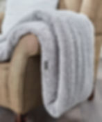 Vegan Ribbon Teddy Bear Throw in pale grey with subtle Vegan Happy logo to the hem shown over a sofa