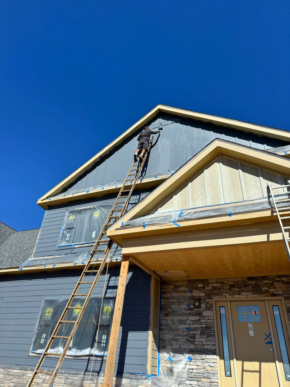 exterior of a newly constructed home in the process of painting blue