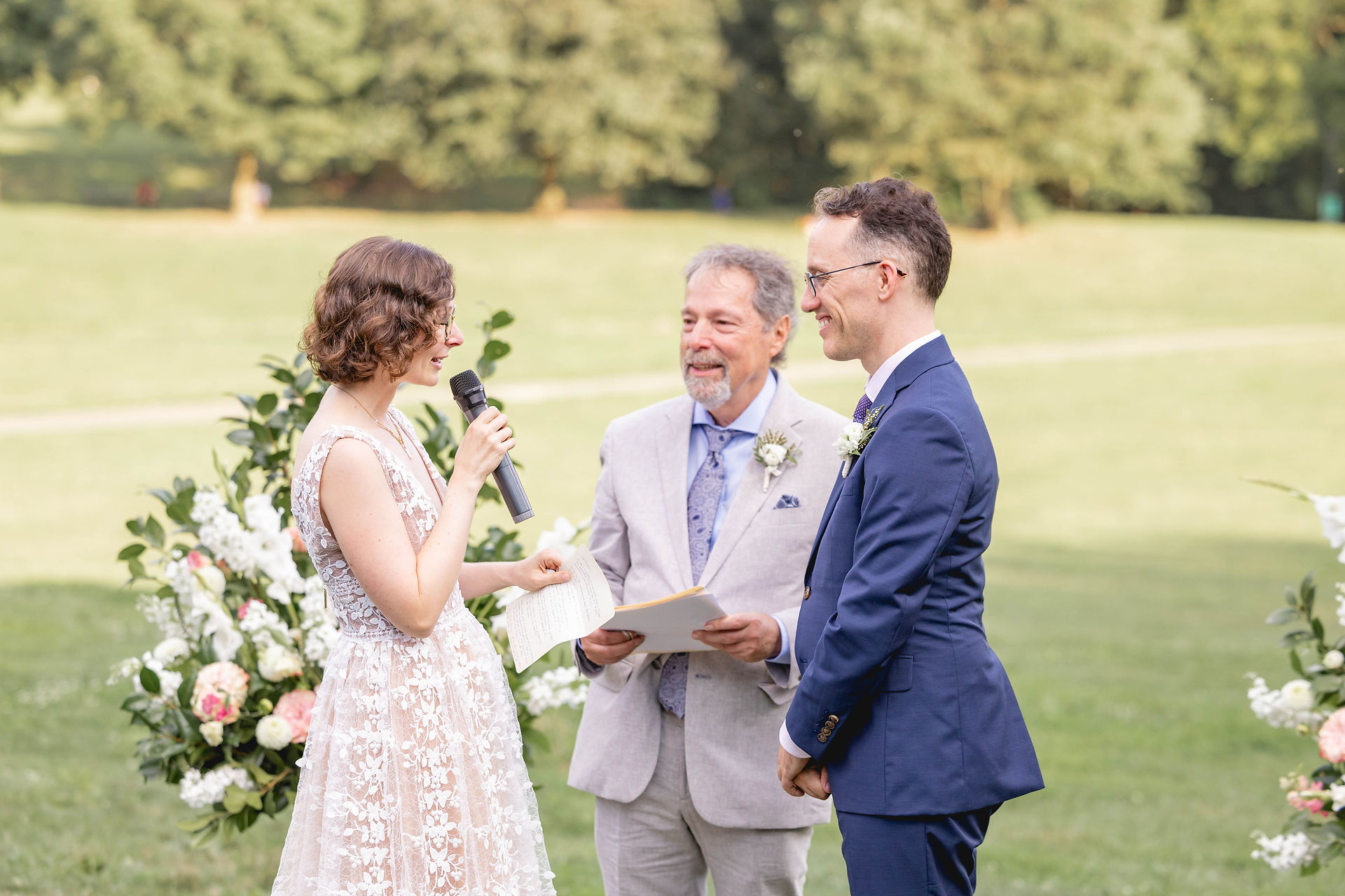 Bride says vows into a microphone in Prospect Park wedding ceremomy