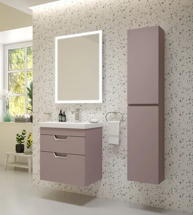 Contemporary bathroom with a cashmere pink floating vanity, matching tall cabinet, illuminated mirror, and a window letting in natural light.