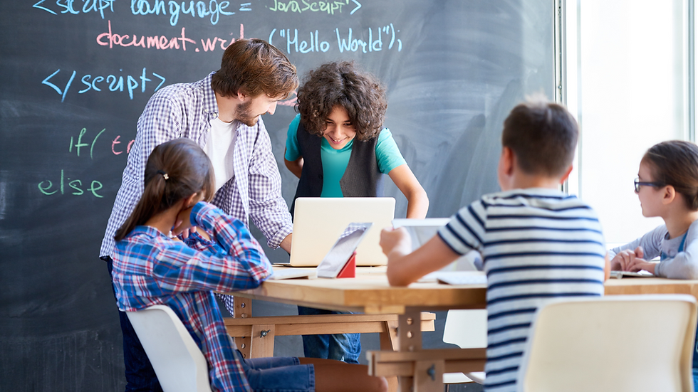 Teens in class coding with teacher