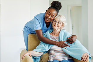 Doctor or nurse caregiver with senior woman, covering her with a blanket, helping and taki