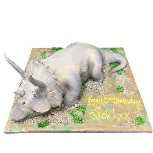 A detailed fondant cake shaped like a Triceratops dinosaur, perfect for a dinosaur-themed birthday party, with intricate details and vibrant colours.