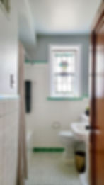 Vintage bathroom with stained glass window in the home of St. Louis interior designer Sharon Derry.