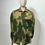 Thumbnail: A mannequin wearing a British Army 1972 Denison Smock Jacket in camouflage green and brown colours. Here with the front zipped up and collar turned down. 