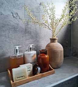 Homeware cluster of bathroom soaps and vase with foliage