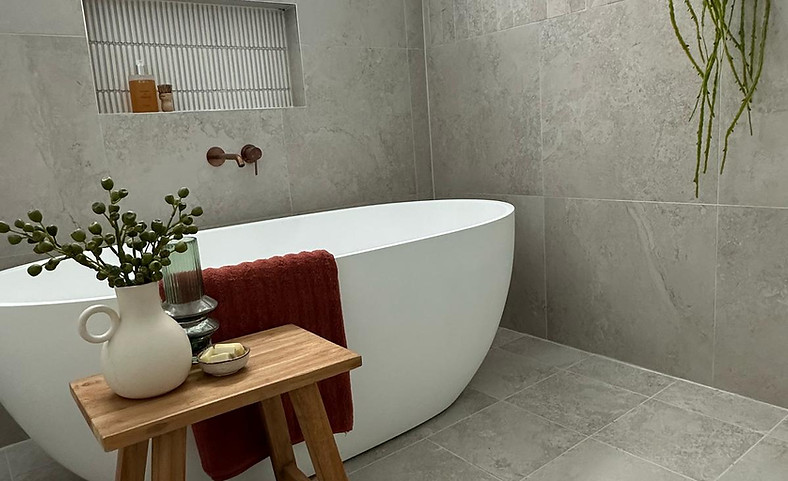 Contemporary bathroom interior design featuring natural stone finishes, freestanding bath and refined styling details