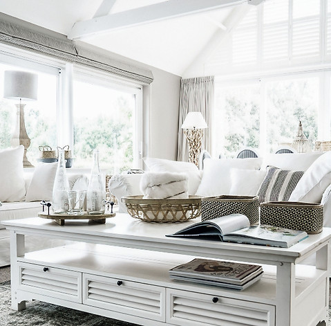 White linen lounge setting with white coffee table and homewares beautifully styled by Home Property Styling