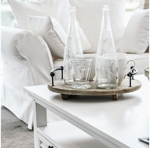 Closeup of white linen lounges and white coffee table with homewares by Home Property Styling