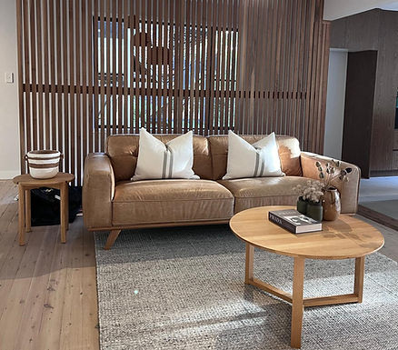 Interior design styling featuring warm timber finishes, leather seating and layered contemporary textures