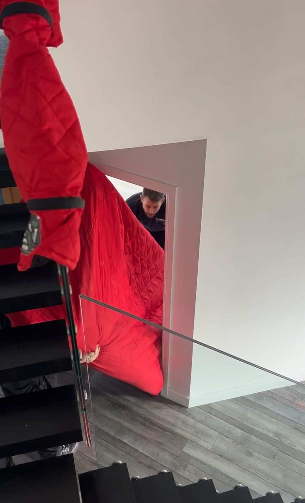 Open Removals getting a sofa in padded covers through a tight doorway