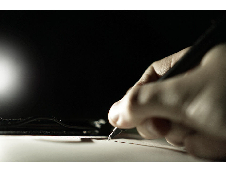 Writer’s hand reaching toward light, symbolizing subconscious storytelling.