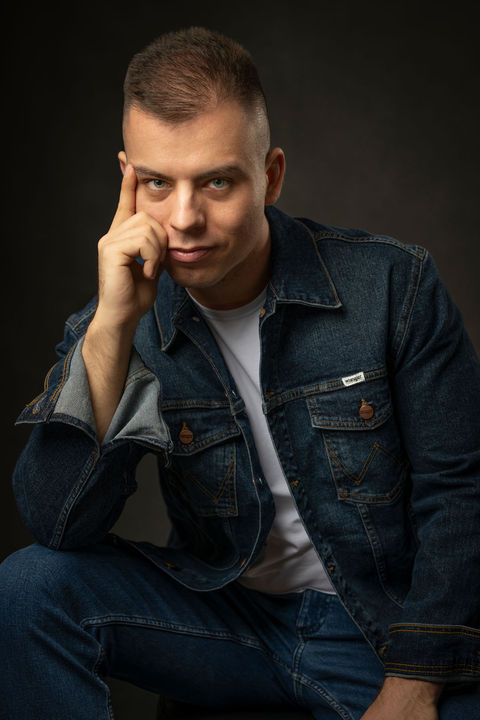 Portret męski w studio Kraków — mężczyzna w dżinsowej kurtce, zamyślona poza