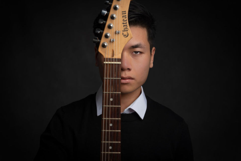 Portret artystyczny mężczyzny z gitarą — sesja meska w studio