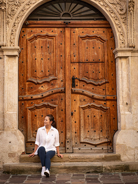 Woman during a private photo session in Krakow, sitting in front of an ornate historic doorway in the Old Town.