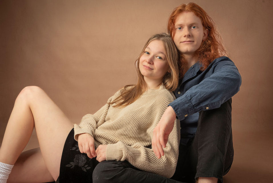 Sesja dla par w studio Kraków — młoda para na ciepłym brązowym tle, naturalna i bliska