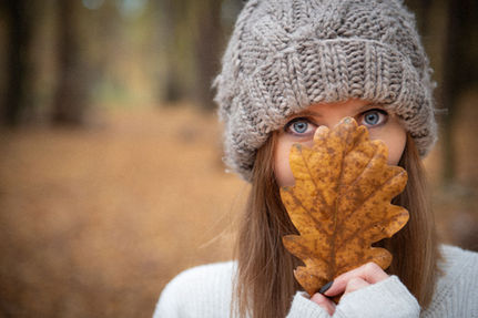 Jesienny portret kobiety w czapce, trzymającej liść — plenerowa sesja zdjęciowa w Krakowie