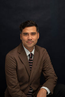 Profesjonalny portret biznesowy mężczyzny w marynarce i krawacie na ciemnym tle — zdjęcie wykonane w studiu w Krakowie