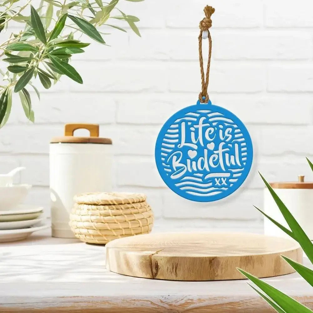 Blue Life Is Budeful powder coated steel wall hanging with jute rope hanging on a wall in stylish kitchen interior