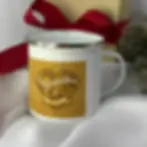 White enamel Congratulations mug with gold wedding rings, styled on a table with white silk cloth and red ribbon