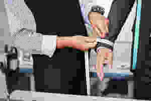 Un sastre mide el brazo de un hombre de negocios para asegurarse de que tiene el traje perfecto.