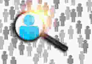 A magnifying glass highlights the perfect job candidate in a crowd.