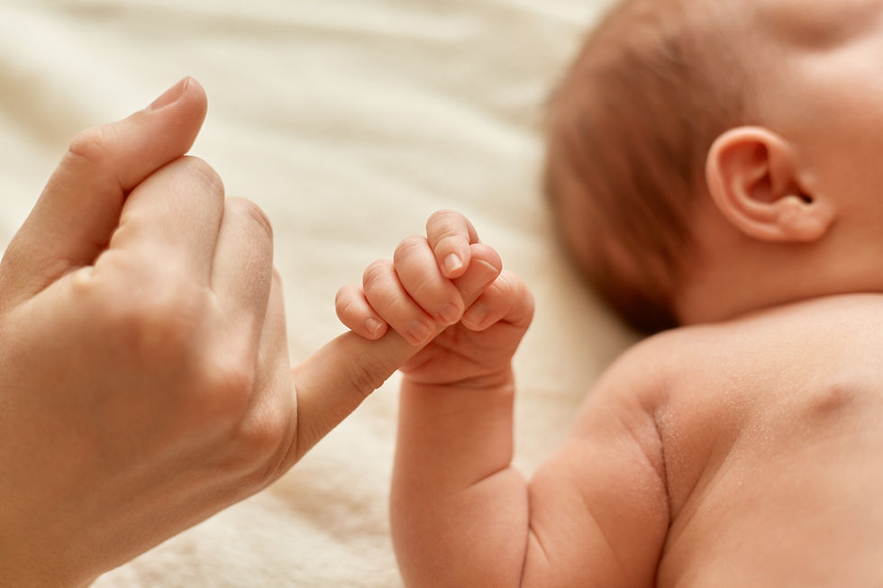 Photo of a baby holding the mother's finger
