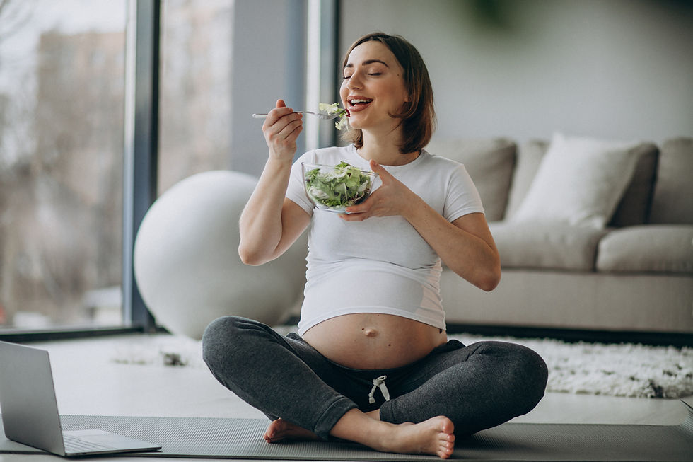 A young pregnant woman enjoying a bowl of salad