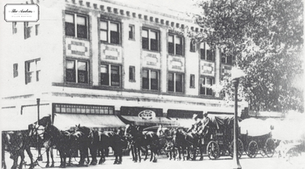 Historic photo of The Andrus Hotel in Dillon, Montana featuring horse-drawn carriages outside the boutique hotel building in the early 1900s.
