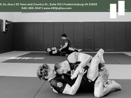 Adults practicing no-gi jiu jitsu during a class at 4:30 Jiu Jitsu in Fredericksburg, Virginia.
