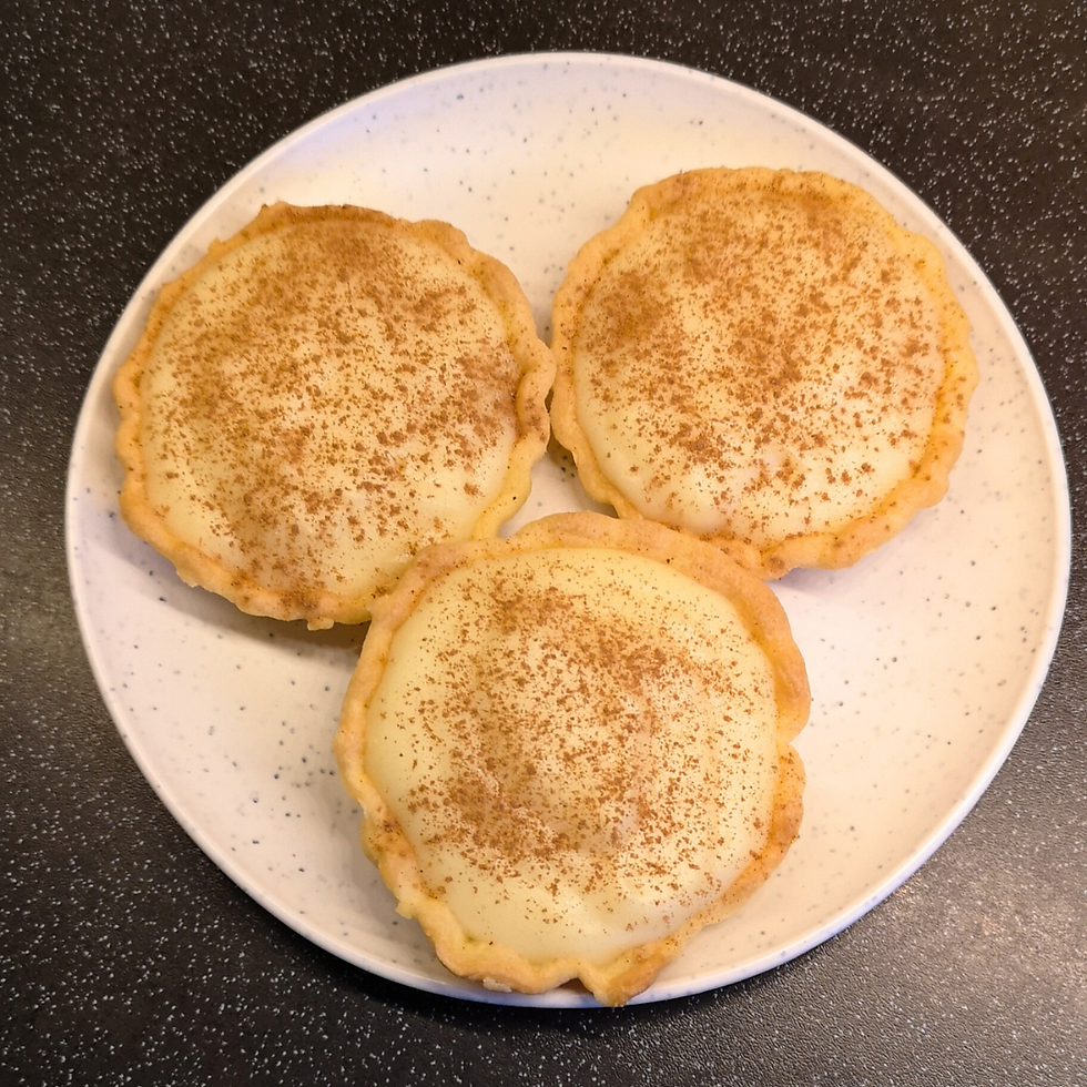 Three mini milk tarts on a plate.