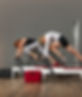 kaksi henkilöä pilates laitteilla