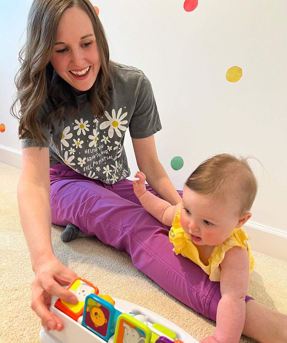 Picture of an occupational therapist engaging a child in a cause and effect toy