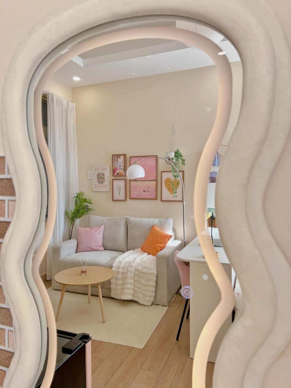 Wavy mirror reflecting cozy, decorated living room.