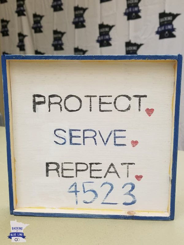 Handpainted craft with the words Protect Serve Repeat badge number 4523
