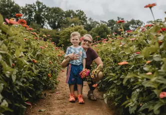 Boy and woman smile in Jeter Mountain Farm zinnia field
