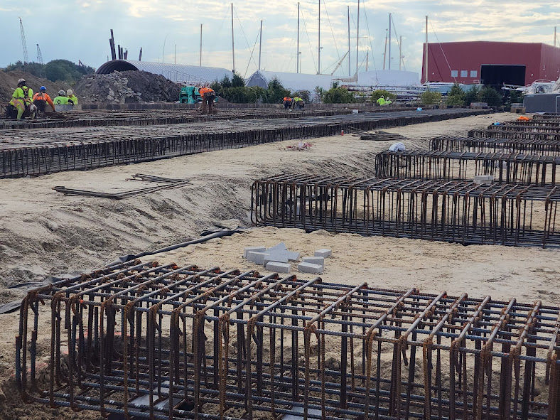 Workers installing reinforcing steel mesh at a construction site