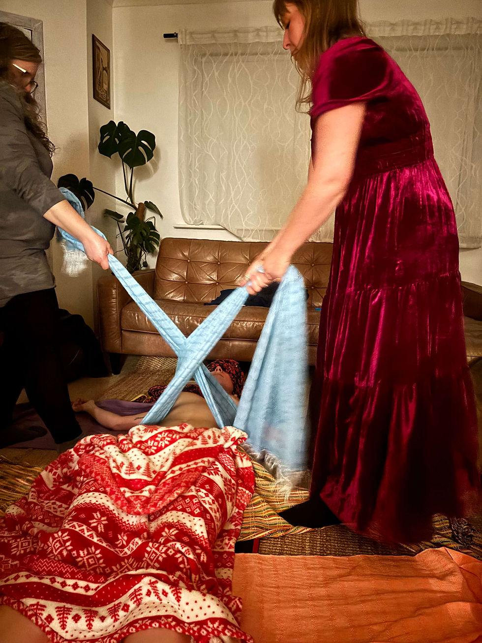 Two women helping another lady with rebozo scarves
