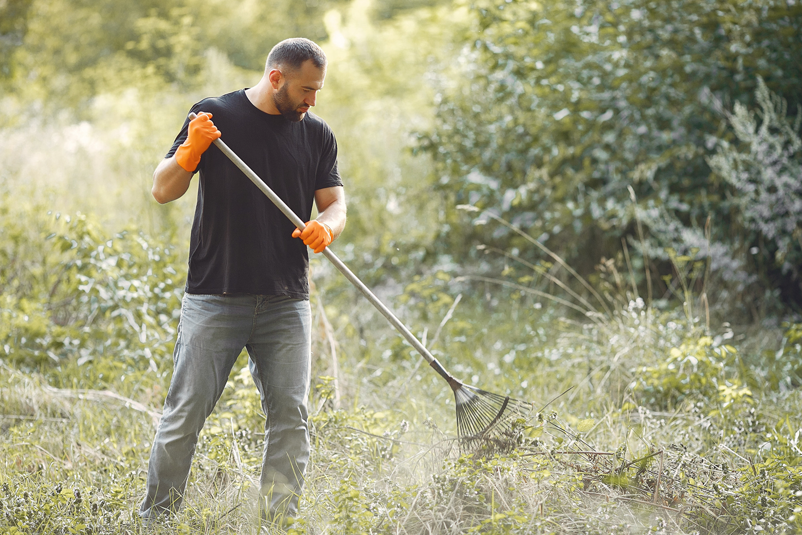 Man using a hoe to prepare land for hardscaping
