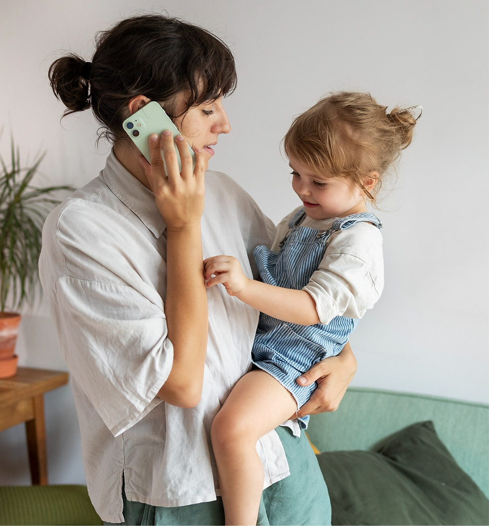 Mother holding toddler, talking on phone