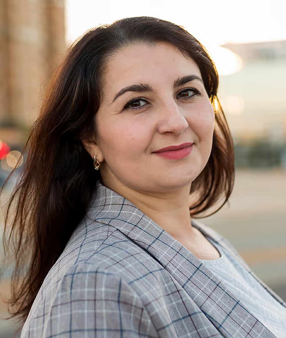 Woman in gray blazer, smiling gently