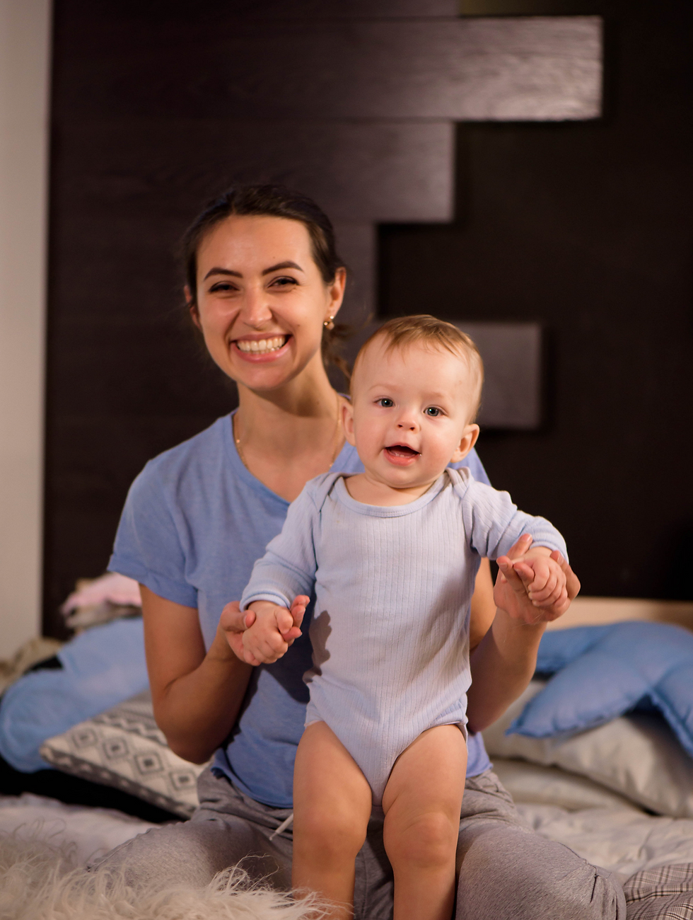 Happy mother and baby holding hands