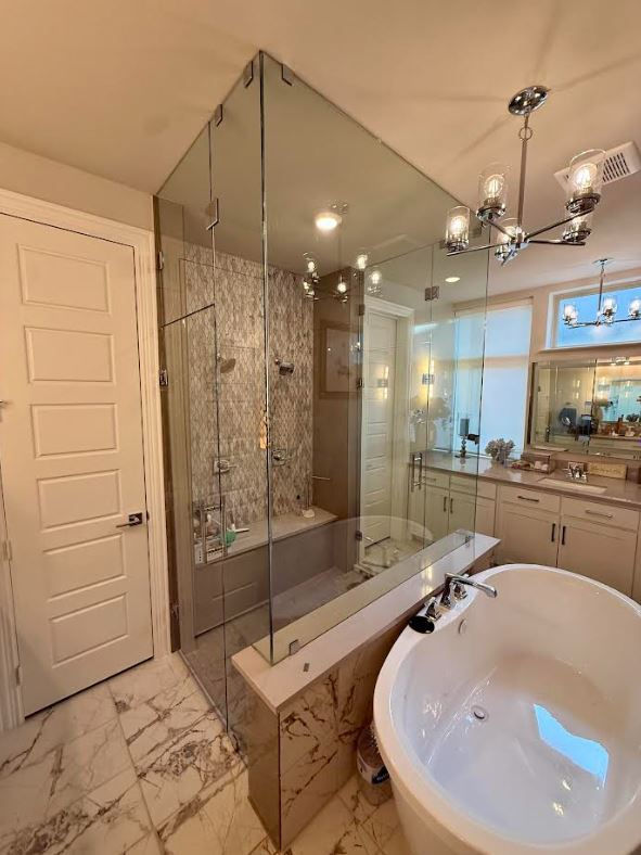 Corner angle of a full-height floor-to-ceiling frameless glass shower enclosure in McKinney, Texas bathroom.